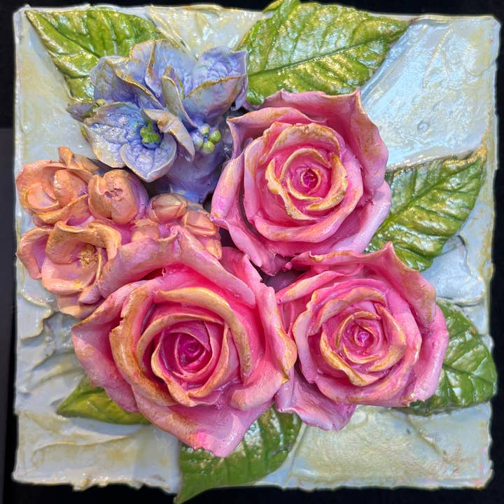 Square clay artwork featuring a floral bouquet relief in earthy tones.