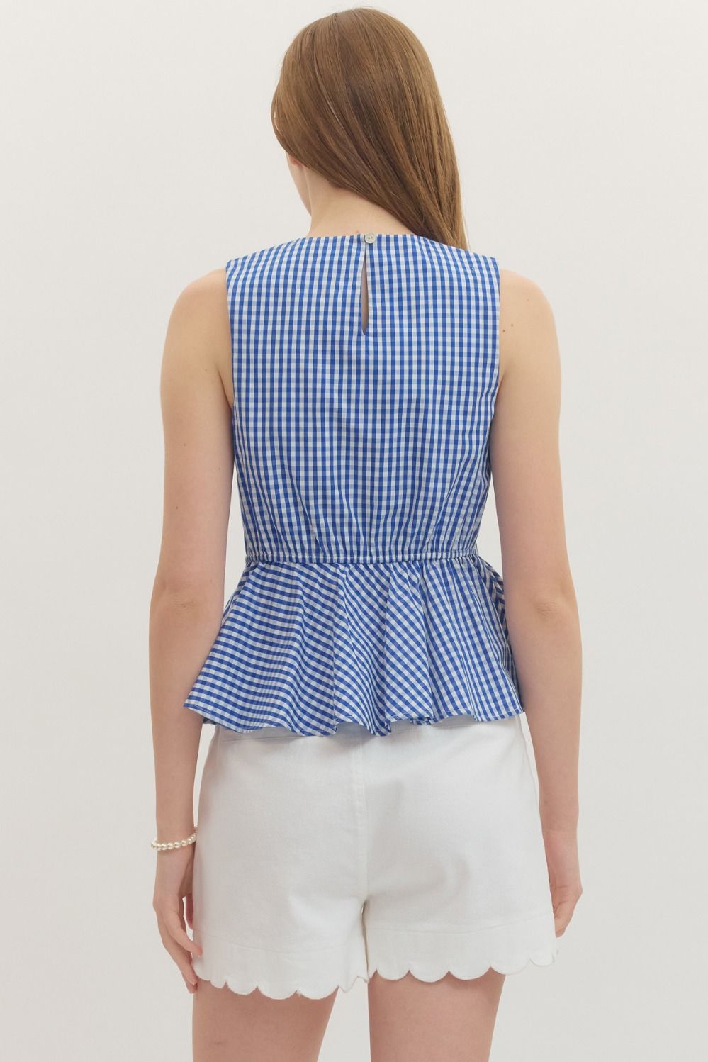 Women's gingham sleeveless peplum top with front ruffle detail and elasticated back waist in cotton.
