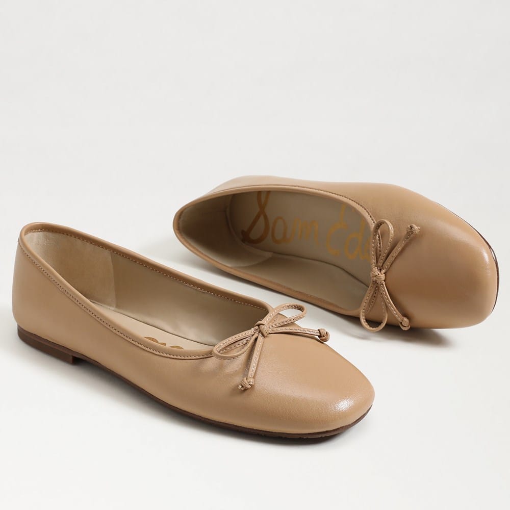 A pair of tan leather Alie Ballet Flats with round toes and decorative bow details.