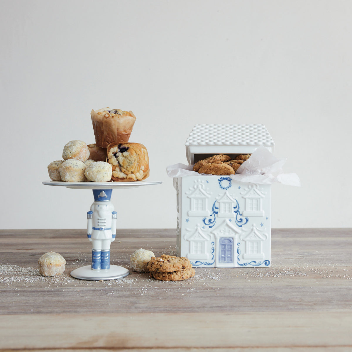 White and blue ceramic nutcracker pedestal stand with silver electroplating holding muffins.