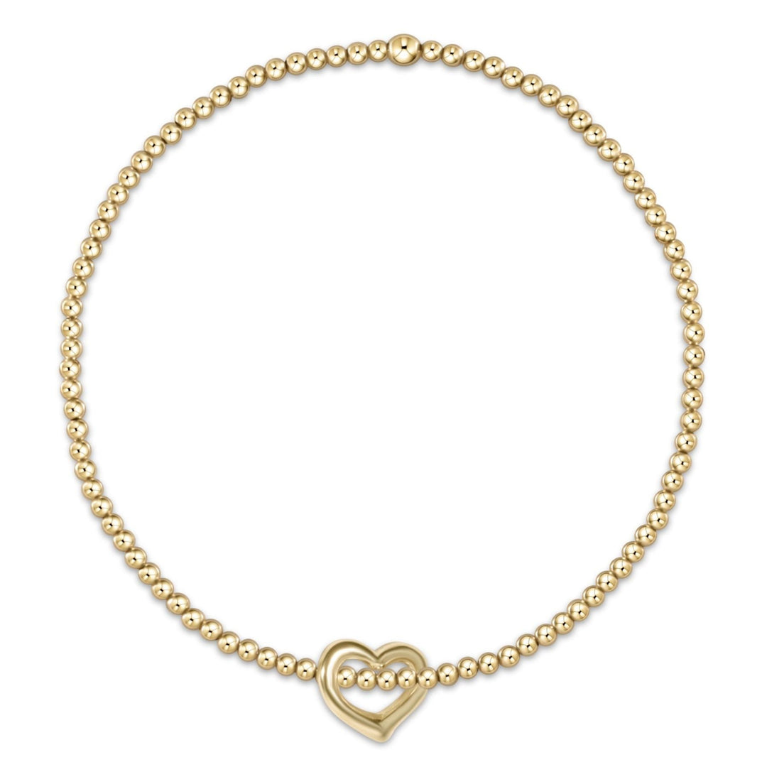 Classic gold bracelet with small love charm on elastic band