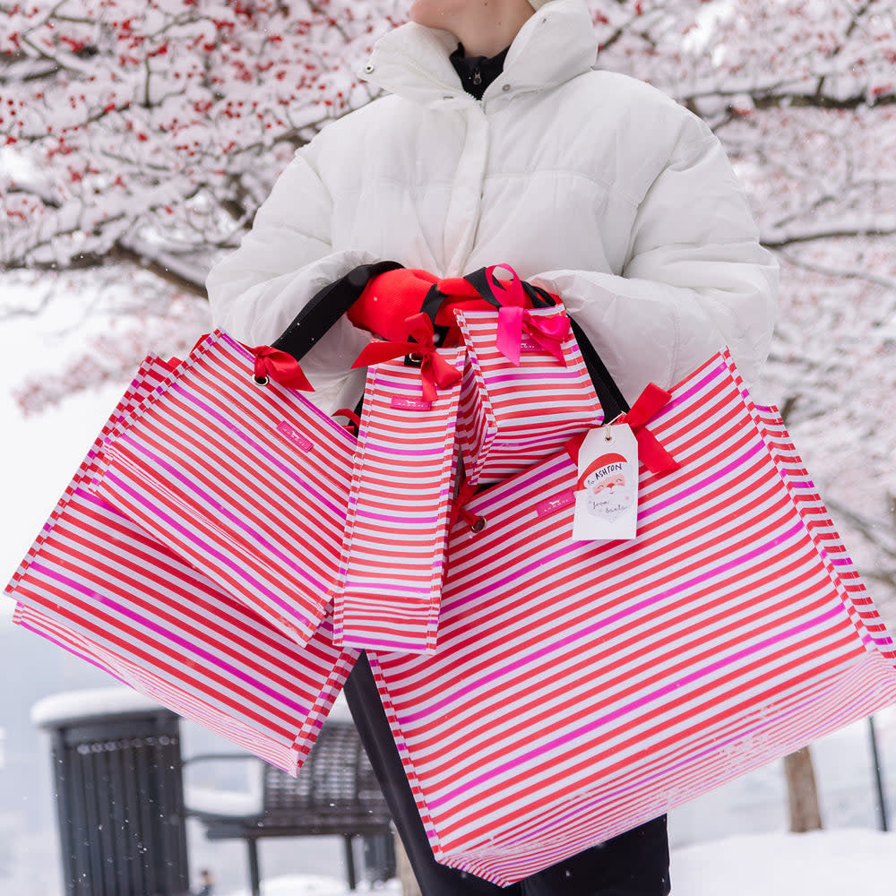 Mini reusable woven gift bag in a colorful geometric pattern with grommets.