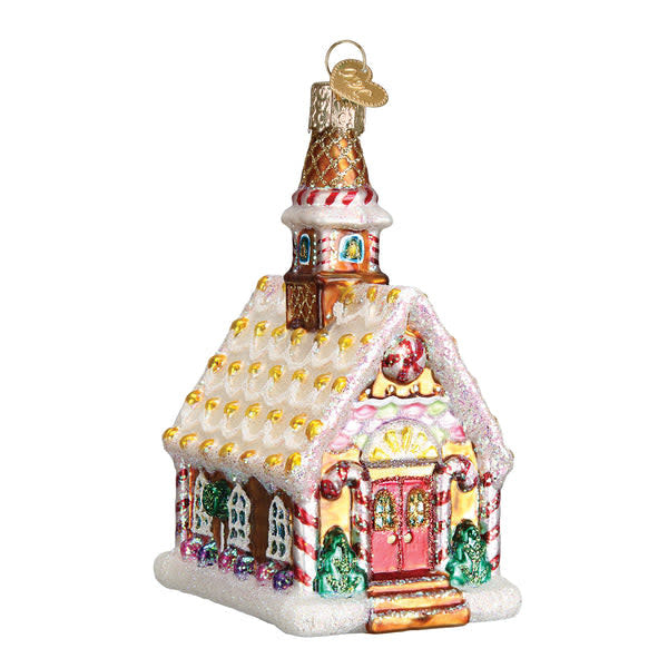 Gingerbread church ornament with white icing windows and a red roof.