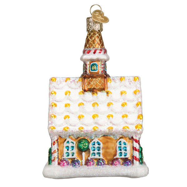 Gingerbread church ornament with white icing windows and a red roof against a dark background.