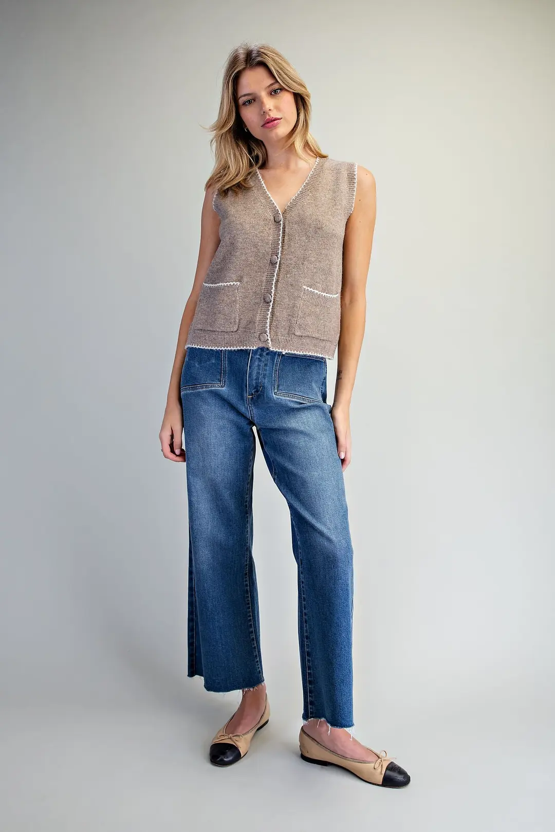 Celeste brown knit vest with white whipstitch trim, button front, and patch pockets.