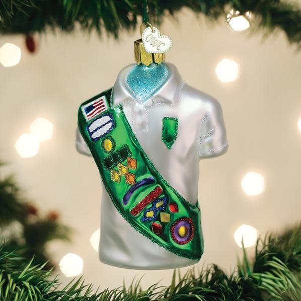 Girl Scout uniform ornament shaped like a scout sash in green fabric with gold trim.