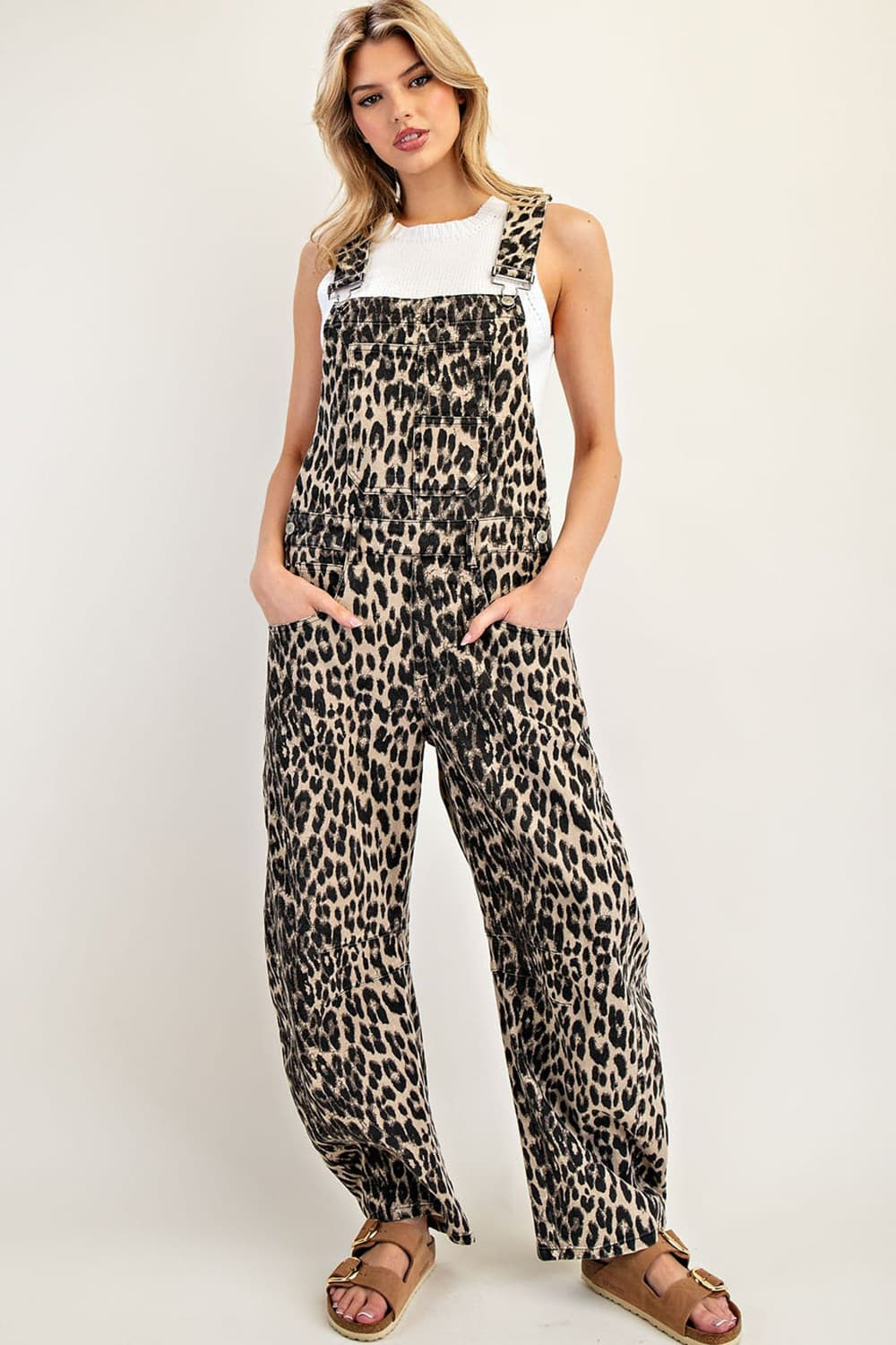 Woman wearing Denise Leopard Printed Barrel Leg Jumpsuit with a white top and brown sandals.