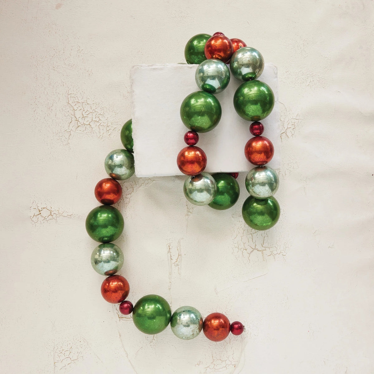 72-inch plastic ball garland with shiny green, red, and silver ornaments on a white background.