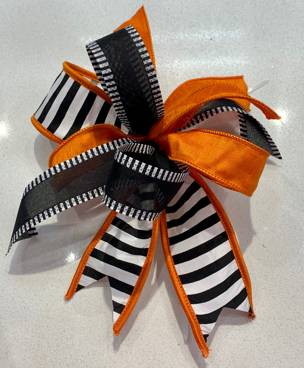 Fall Bow 7 featuring orange and black-and-white striped ribbons on a white surface.