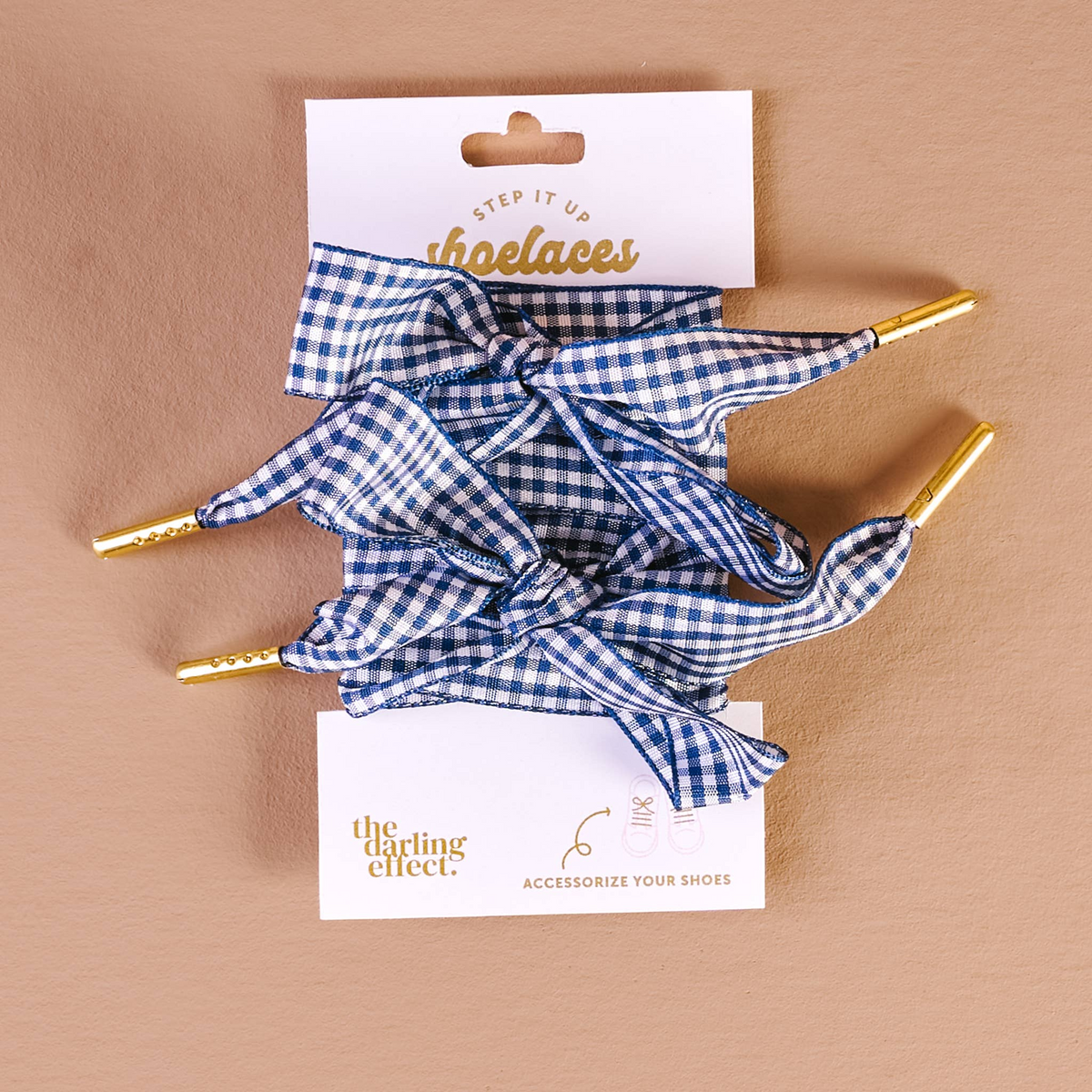 Blue and white gingham shoelaces with gold metal aglets on a white display card.