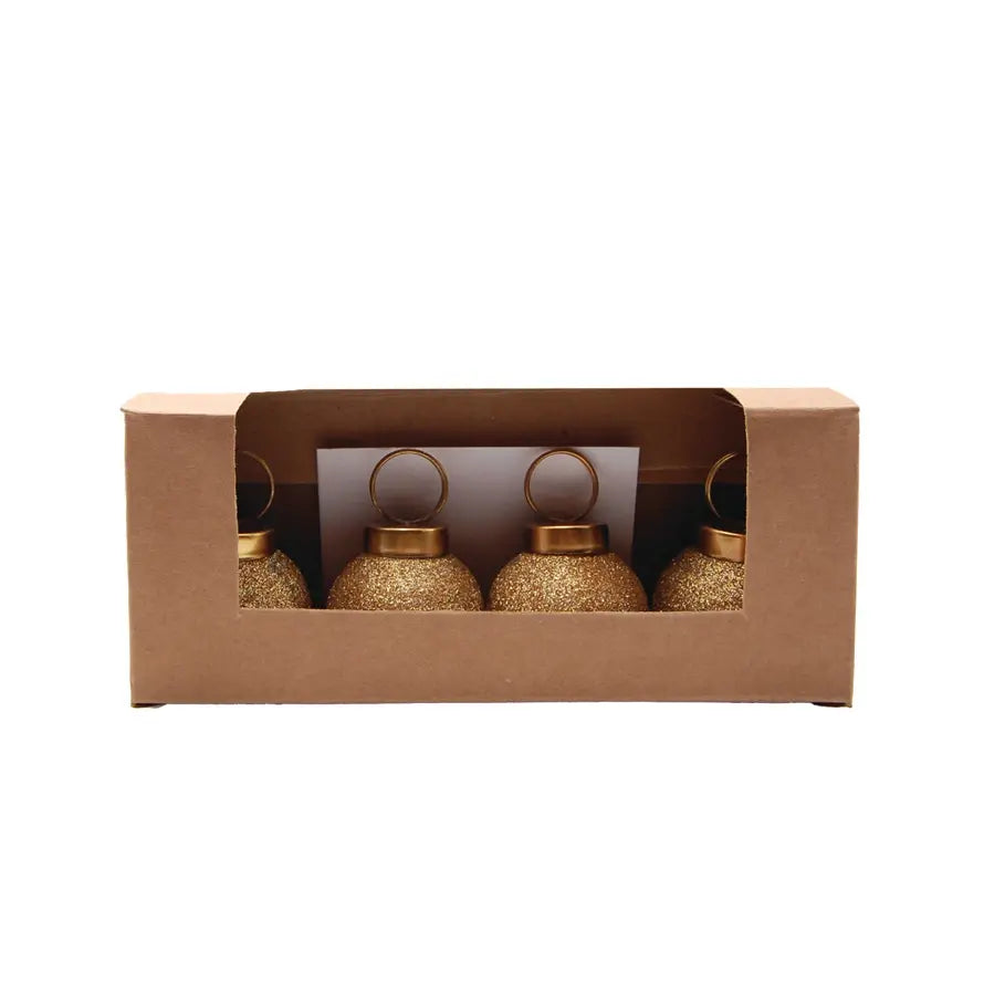 Set of glass ball ornament card holders with festive red accents holding greeting cards.
