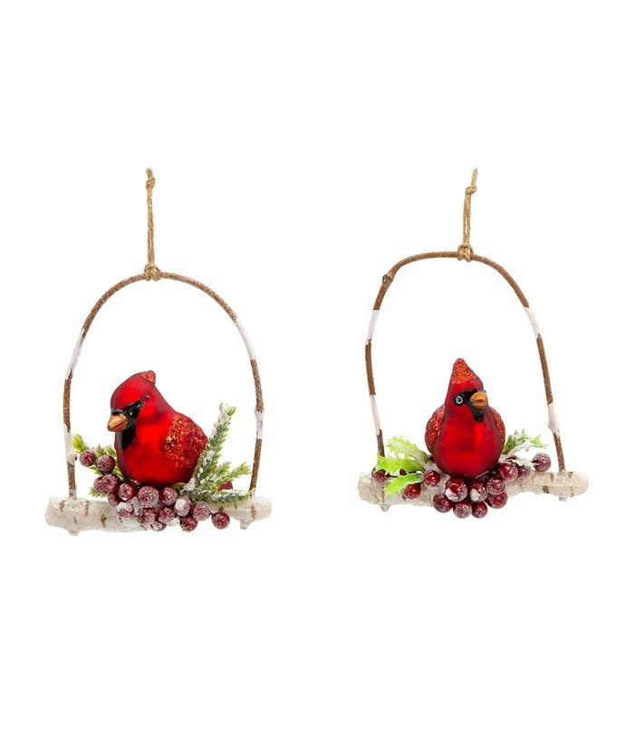 Glass ornament featuring a red cardinal perched on a branch with glittered berries.