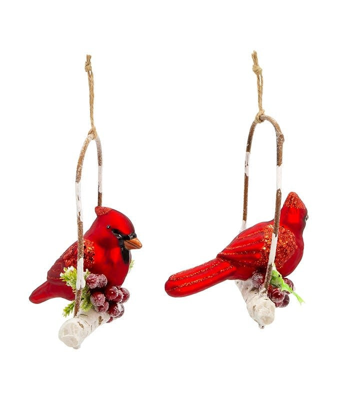 Glass ornament shaped like a red cardinal perched on a branch with glittered berries and leaves.