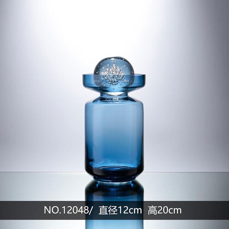 Clear glass vase with a sleek cylindrical shape designed to hold floral arrangements.