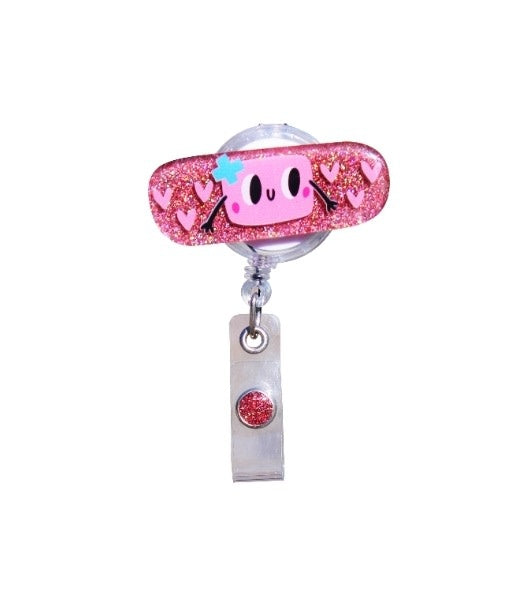 Glitterific badge reel with band-aid shape featuring sparkly glitter resin material and a black alligator clip.