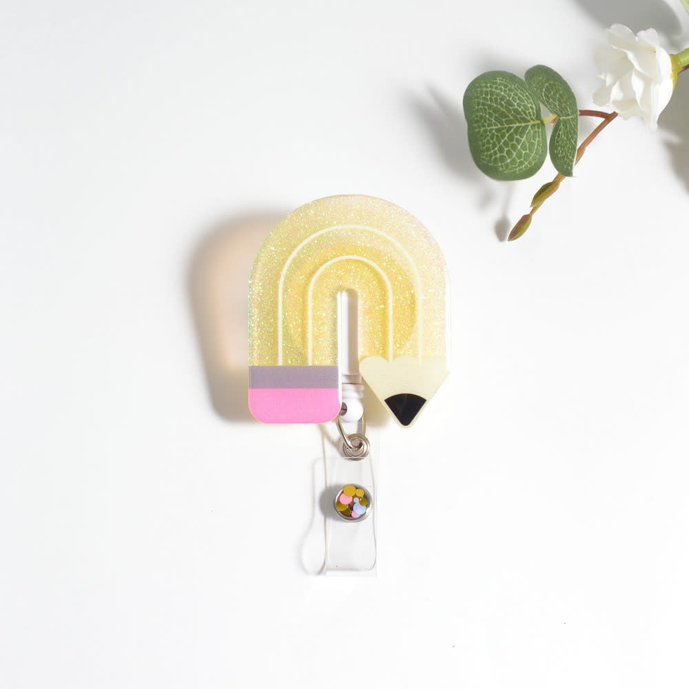 Glitterific badge reel with a glitter resin pin featuring pink sparkly stars on white.