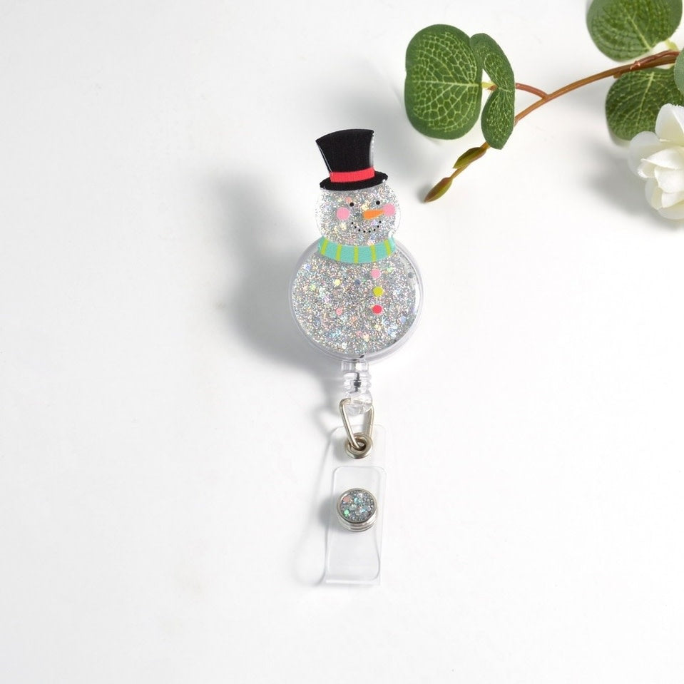 Glitterific badge reel featuring a snowman face in glitter resin with a black alligator clip.