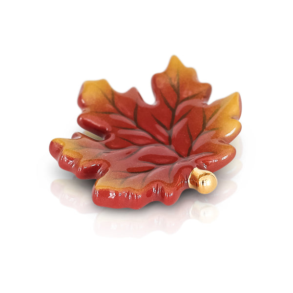 Ceramic maple leaf dish in red and yellow with a gold accent.