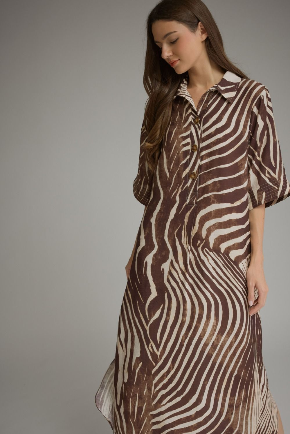 Woman wearing the Juris Abstract Zebra Print Elbow Sleeve Midi Dress in brown and cream.