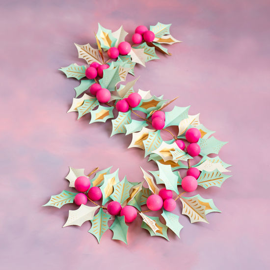 92-inch paper mache holly garland with mint green and gold leaves and bright pink berries.