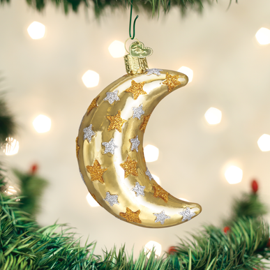 Gold crescent moon ornament with silver and gold glitter stars hanging on a Christmas tree.