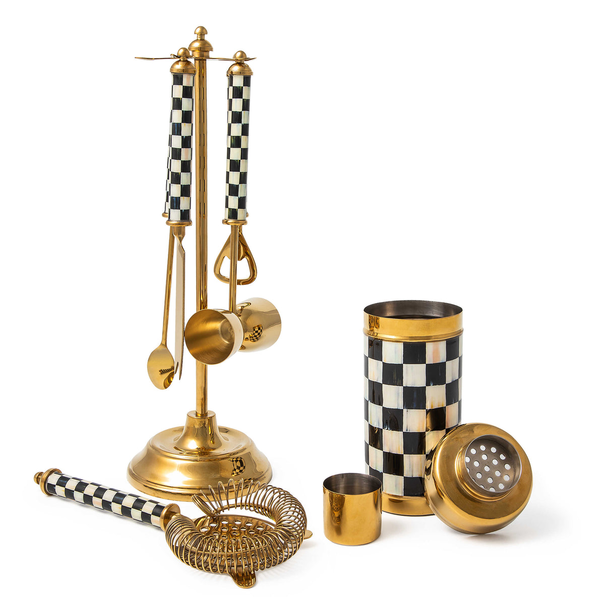 Gold bar set with black and white checkered handles, including a shaker, strainer, and tool stand.