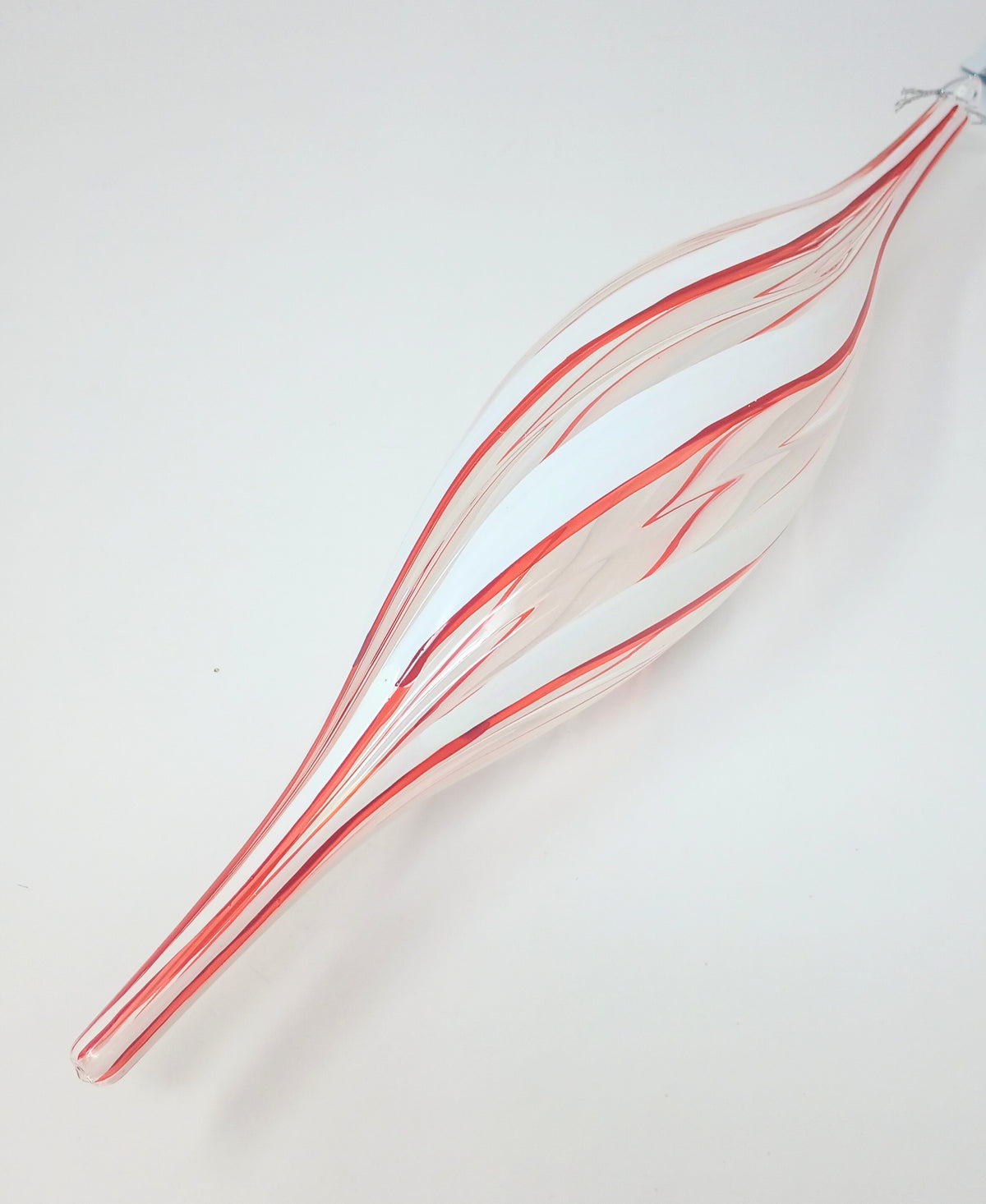 Red and white striped glass finial Christmas ornament with a tapered, elongated shape.
