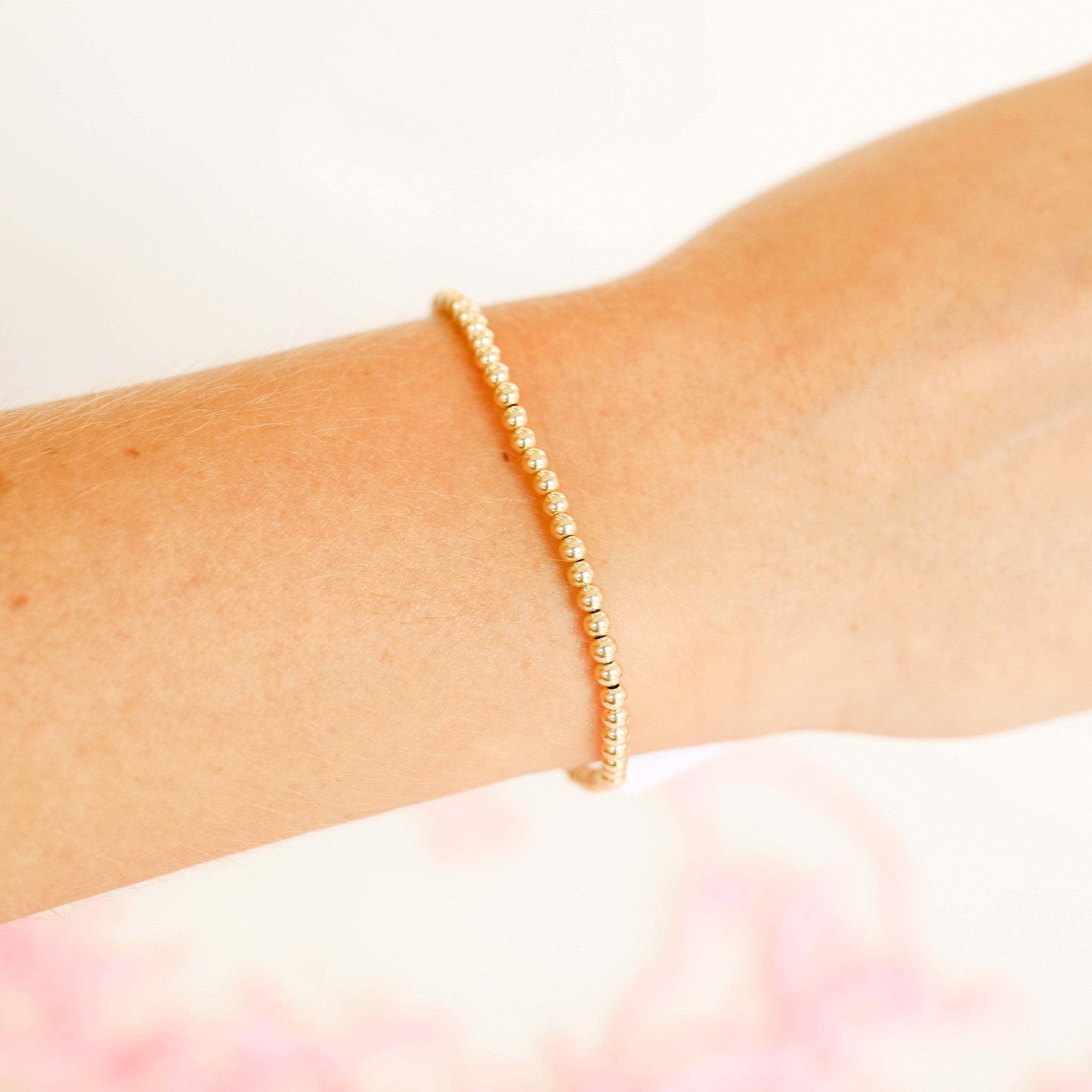 Elastic gold beaded bracelet with a simple stacked stack style.