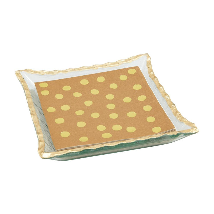 Glass napkin caddy with gold rim holding folded white napkins