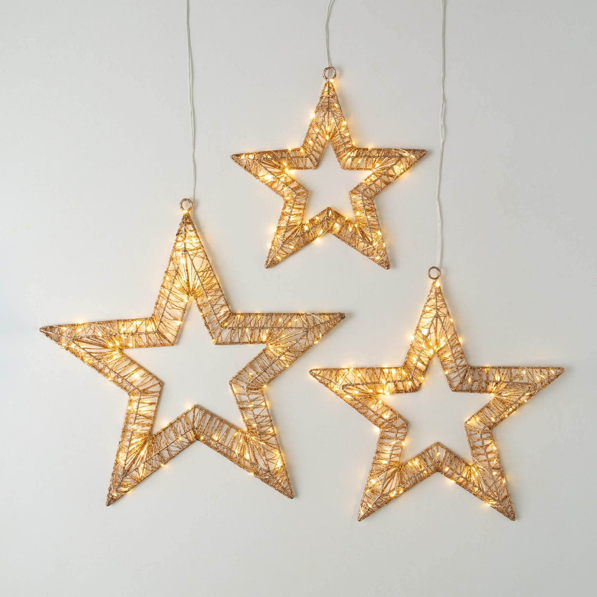 Gold metal star-shaped outdoor light fixture with warm white LEDs.