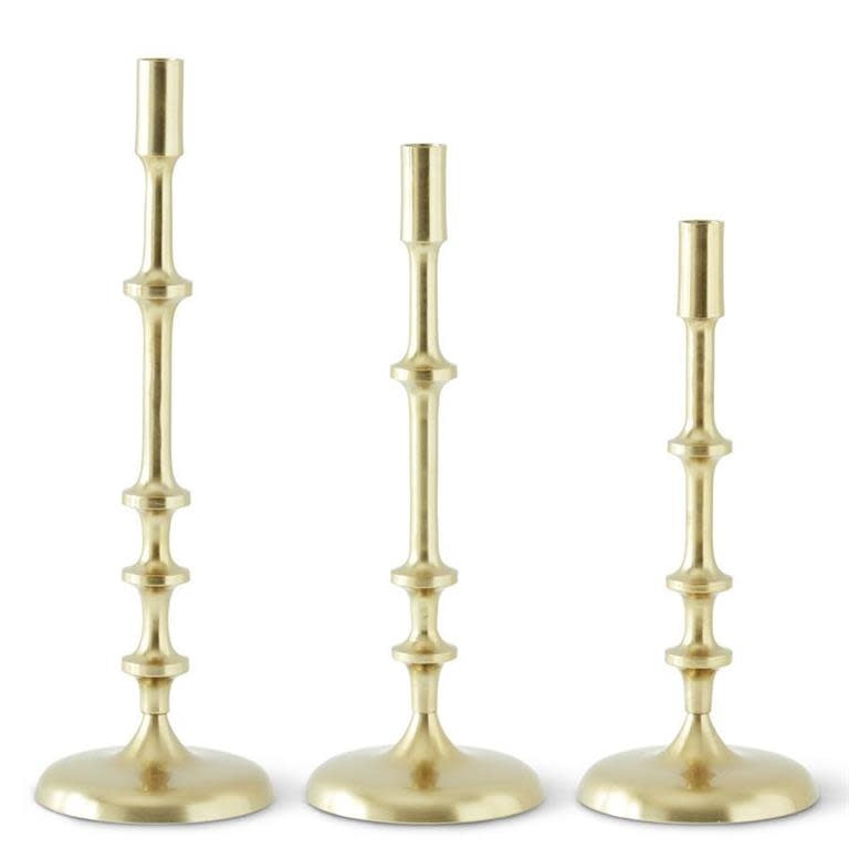 Gold metal ribbed candlestick with elegant vertical texture on an aluminium base.
