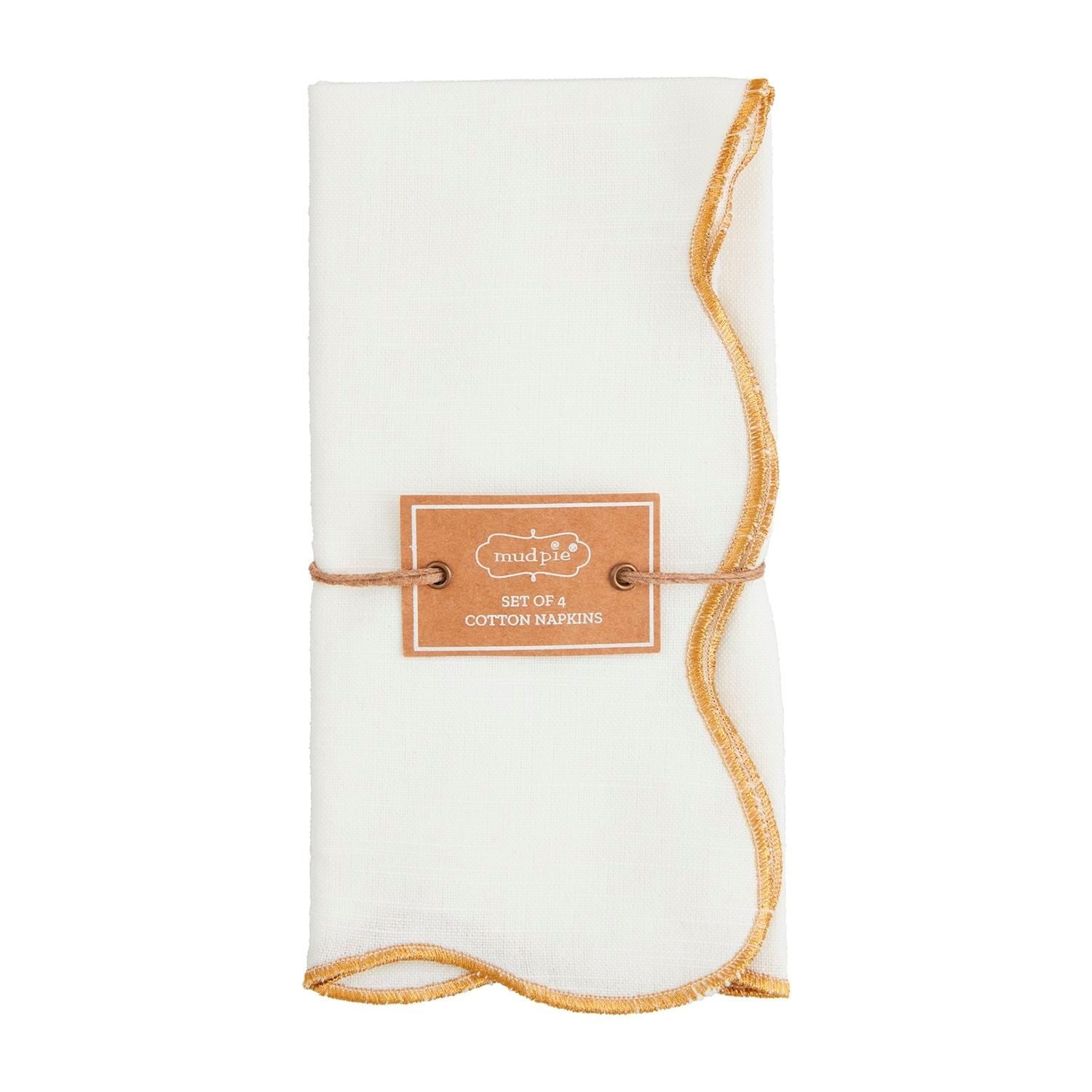 Four gold scallop-edge cotton dinner napkins arranged on a neutral surface.