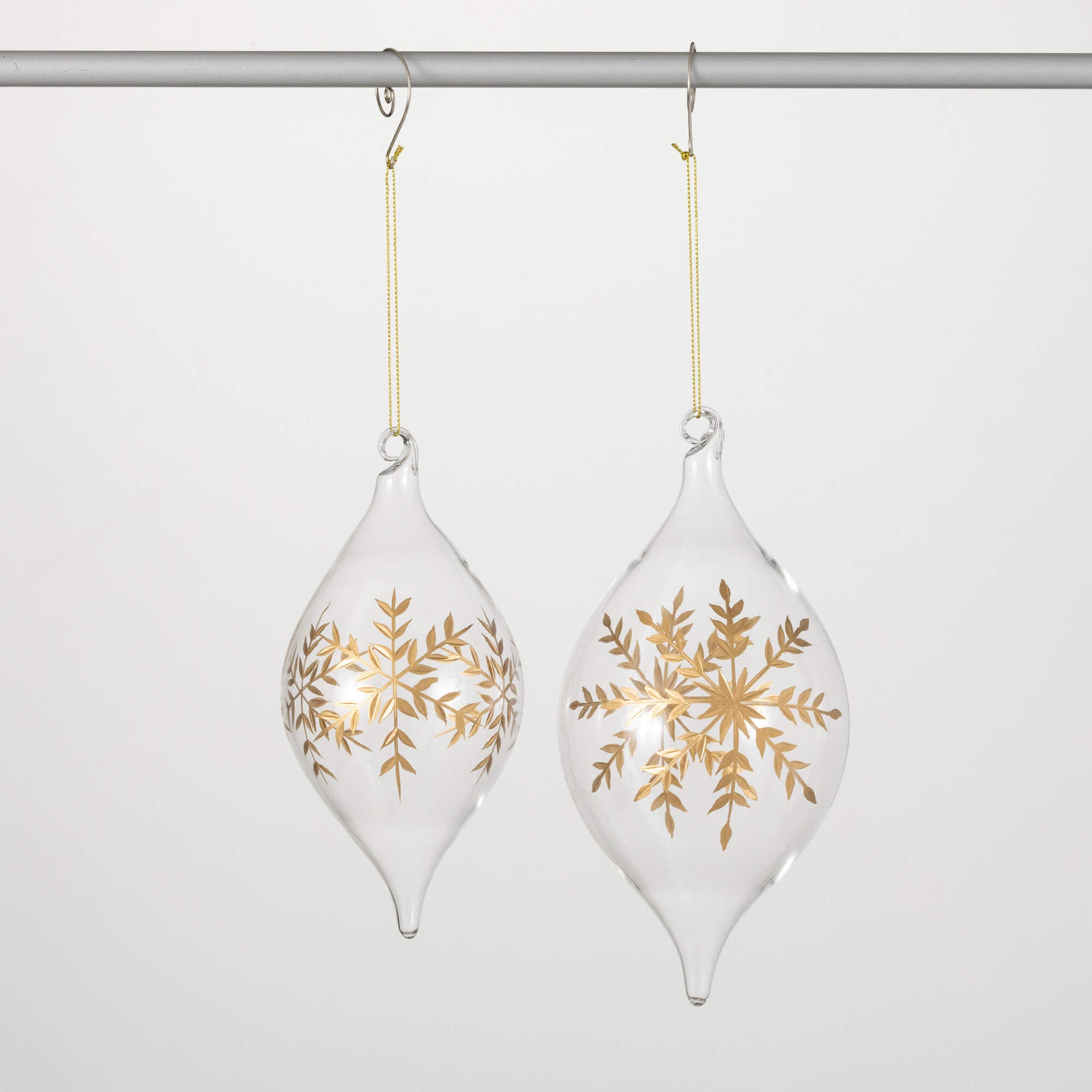 Glass Christmas ornament with gold snowflake embellishments on a white onion shape.