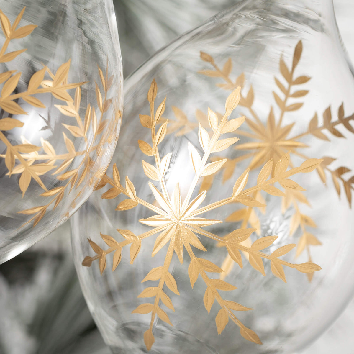 Glass Christmas ornament shaped like an onion with gold snowflake embellishments.