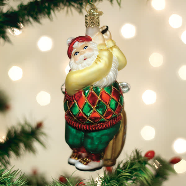 Golfing Santa ornament featuring a red-suited figure holding clubs on green grass.