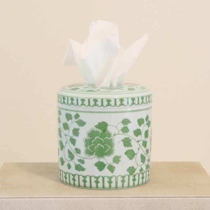 Cylindrical white ceramic tissue vessel with green floral patterns and a tissue emerging from top.