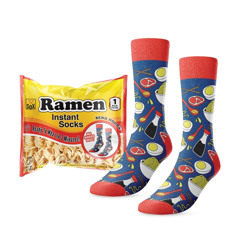 Instant Ramen Noodle Socks in blue with food patterns next to their yellow ramen-style packaging.