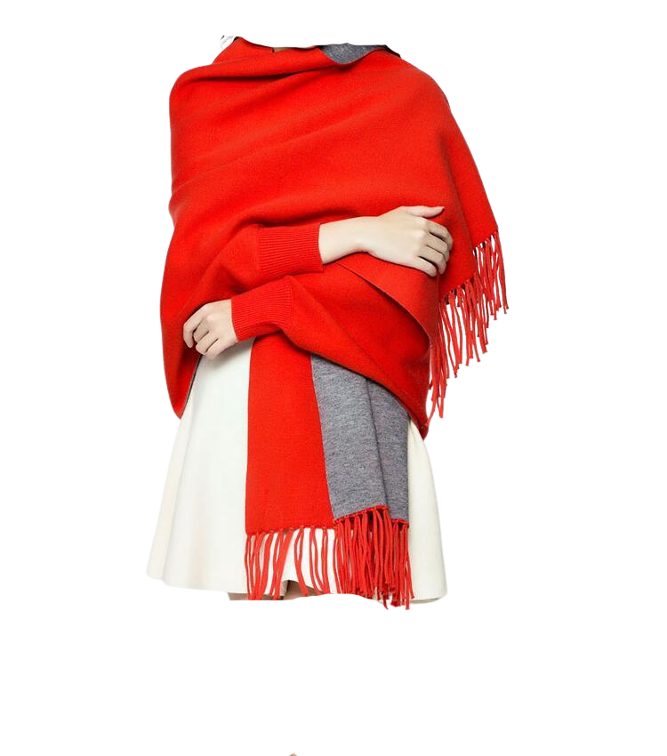 Red and grey reversible wrap poncho with sleeves and fringe trim over a white skirt.