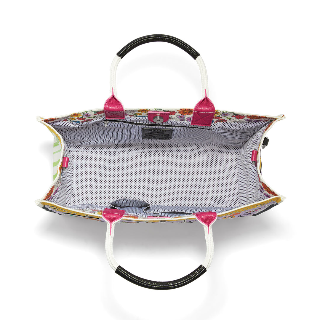 Interior view of a large canvas tote with polka dot lining, magnetic snap, and multiple pockets.