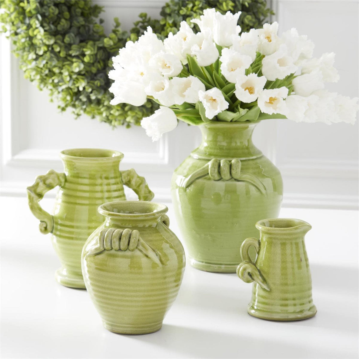 Green ceramic vase with a sleek cylindrical shape.
