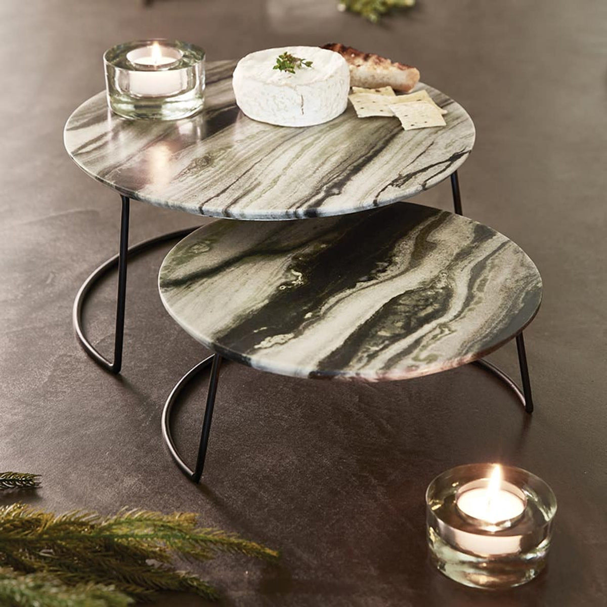 Nested grey marble trays with dark green veining on an iron base