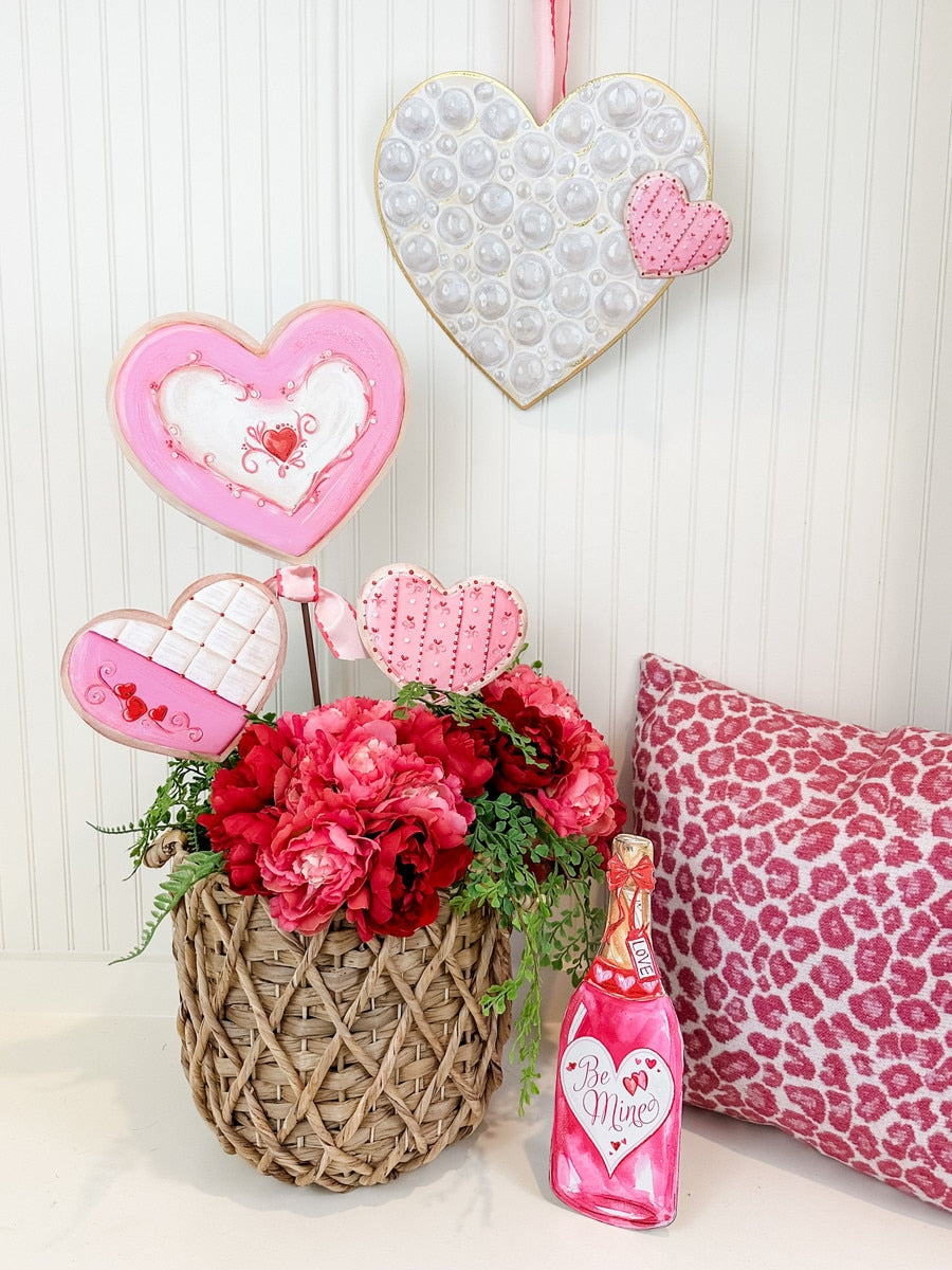Valentine's Day display with heart-shaped cookies, pink flowers, and a champagne bottle decoration.