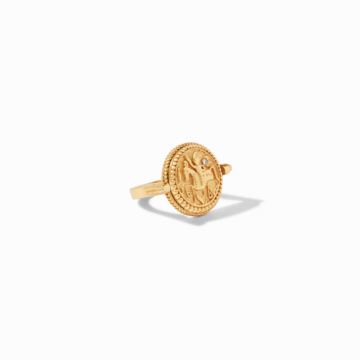 Gold revolving coin ring with an embossed figure and a small clear stone detail.