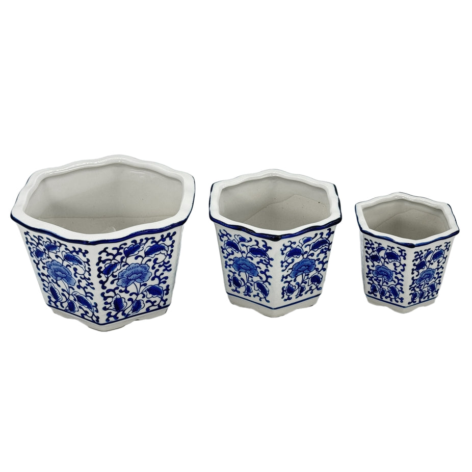 Three blue and white hexagon ceramic planters with floral patterns and ruffled lips in varied sizes.