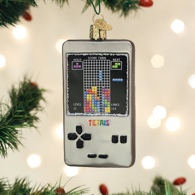 Glass Tetris handheld game console Christmas ornament hanging on a tree.