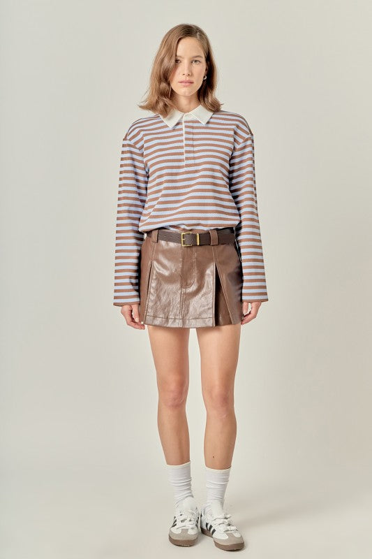 Woman wearing the Gina Rugby Polo Shirt in a brown and blue stripe with a brown leather mini skirt.