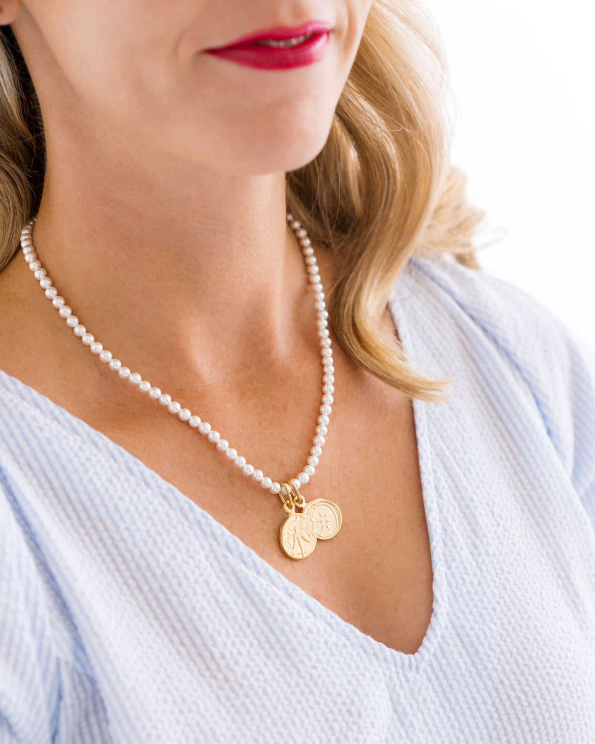 Woman wearing the Widow's Mite Pearl Necklace with two gold coin charms and freshwater pearls.