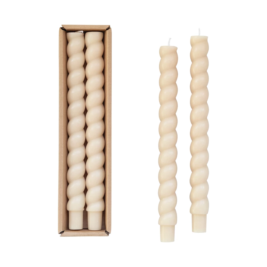 Box containing cream-colored twisted taper candles with a smooth texture.