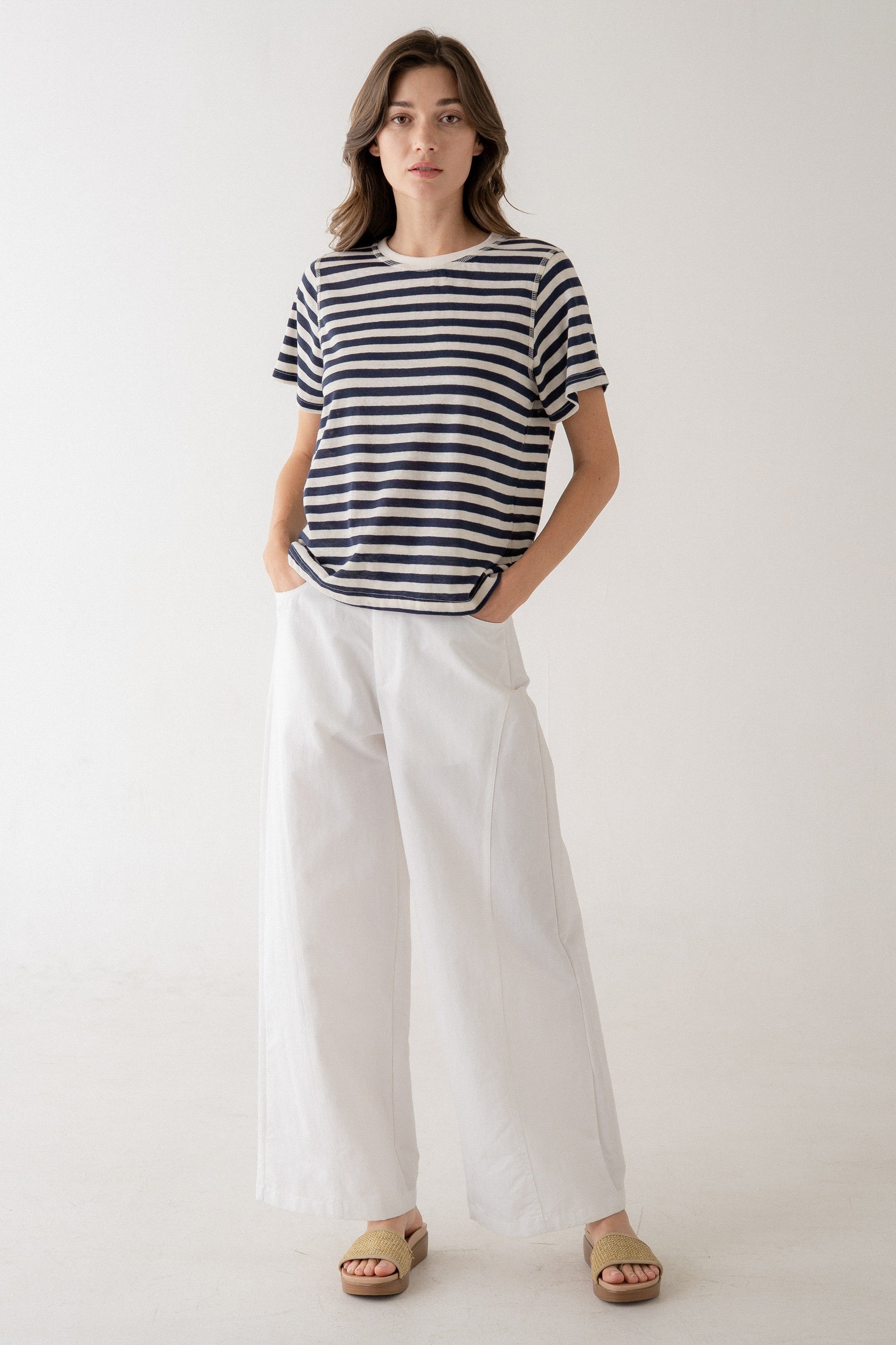 Woman wearing a Camila Classic Bold Stripe Crew Tee in navy and white with wide-leg white trousers.
