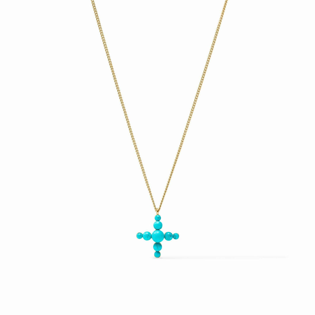 Turquoise blue reconstituted stone cross pendant on a delicate gold curb chain necklace.